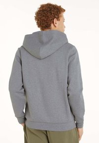 Felpa grigia con cappuccio realizzata in tessuto morbido. Presenta una vestibilità comoda, maniche lunghe e una classica tasca a marsupio sul davanti.