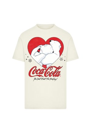 Cream-colored cotton T-shirt featuring two polar bears in a red heart, holding a Coca-Cola bottle, with a logo and tagline below.