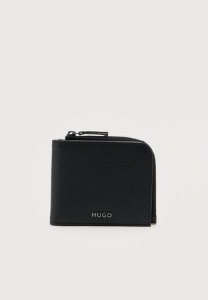 Portefeuille en cuir noir avec fermeture éclair, avec le nom de la marque "HUGO" en argent sur le centre avant.