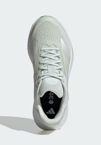 Lichtgroene sportschoen met een textuur bovenkant, witte accenten, vetersluiting en Ortholite binnenzool. Rubberen zool biedt grip.
