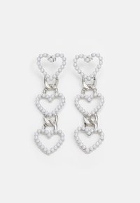 White heart-shaped earrings made of beads, linked by silver hardware, featuring three layered heart designs.