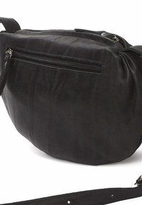 Zwarte leren schoudertas met een zachte textuur, een ritsvak aan de voorkant en een lange verstelbare band. Ronde vorm met minimale hardware.