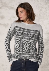 Pull gris avec des motifs géométriques noirs, col rond, manches longues et poignets côtelés. Tissu tricoté doux et coupe décontractée.