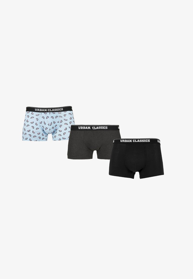 Three pairs of men's trunks: one light blue with a pattern of red and black shapes, one dark gray, and one solid black; all with black waistbands.