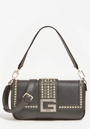 Sac à main en cuir noir texturé avec une bandoulière amovible, orné de clous en argent, d'un fermoir décoratif et d'un logo prominent sur le devant.