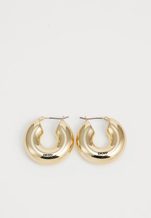 Orecchini a cerchio in oro con un design liscio e arrotondato e una finitura lucida, dotati di un gancio per la chiusura. Incisi con "DKNY."