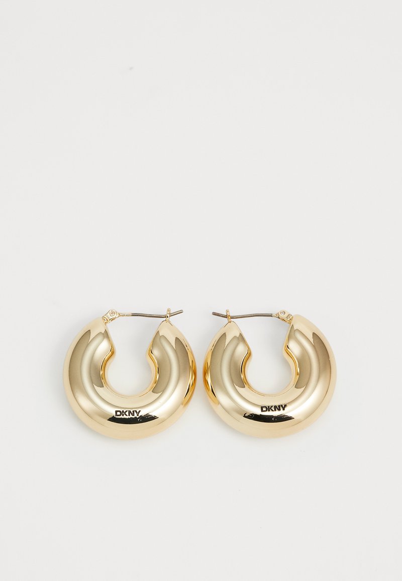 Pendientes de aro de oro con un diseño liso y redondeado y un acabado brillante, que cuentan con un cierre para asegurar. Grabados con "DKNY".