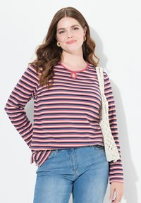 Chemise à rayures à manches longues en rouge, marine et blanc, dotée d'un col rond avec une découpe en forme de clé et d'un ourlet légèrement arrondi.