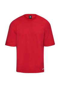 Camiseta de algodón roja con cuello redondo y mangas cortas. Presenta un corte recto y una pequeña etiqueta en el dobladillo. Diseño simple de un solo color.