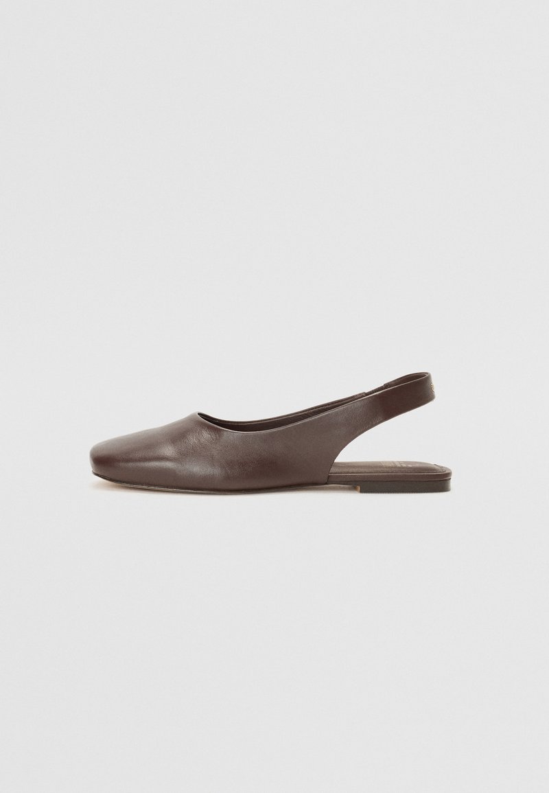 Brūna ādas slingback kurpe ar noapaļotu purngalu, minimāla dizaina, plakanu zoli un atvērtu aizmuguri vieglai uzvilkšanai. Gluda tekstūra, bez redzamām rotājošām detaļām.