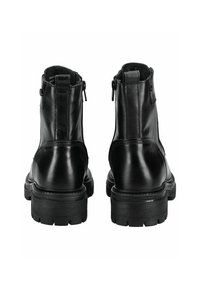 Botas de tobillo de cuero negro con un acabado suave, punteras redondeadas y suela gruesa. Presentan cremalleras laterales para facilitar el uso.