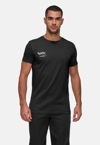 Svart t-shirt med kort ärm i bomullsblandning, med vita grafiktryck på vänster bröst, rund halsringning och standard passform.