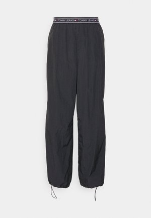 Crne sužene hlače s elastičnim pojasom i logotipom "TOMMY JEANS". Lagani, glatki materijal s vezicom na manžetama.