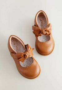 Braune Leder-Mary-Jane-Schuhe mit einer großen, geknoteten Schleife, durchbrochener Verzierung an der Zehenpartie und einer flexiblen Gummisohle.