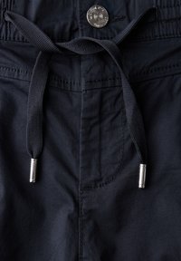 Shorts bleu marine avec un waistband à cordon de serrage, un bouton en métal argenté et un tissu lisse avec des détails de couture visibles.
