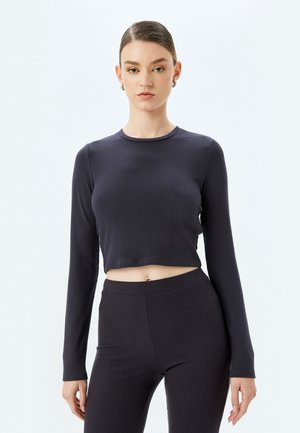 Mørkeblå, cropped langærmet top i ribbet tekstur med rund halsudskæring og tætsiddende design, parret med matchende ribbede højtaljede bukser.