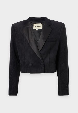 Zkrácený černý blazer vyrobený z texturované tkaniny se saténovými klopami a dvouřadým zapínáním. Obsahuje jedno náprsní kapsu na levé straně.