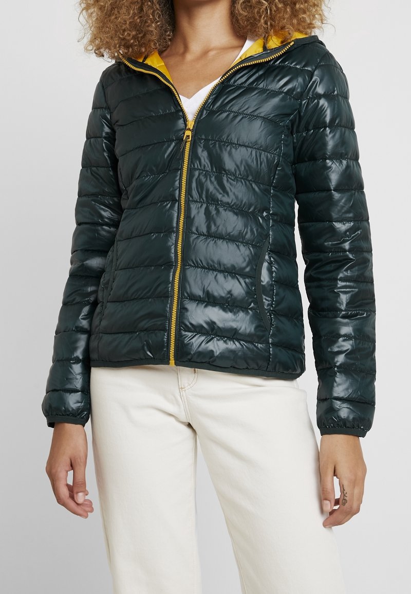 Mörkgrön pufferjacka med en glänsande ytfinish, gul innerfoder, två sidofickor och dragkedja framtill. Lätt kviltad design.