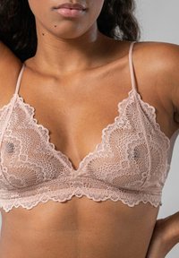  pitsipitslinen vaaleanpunainen pitsibandeau, jossa on herkät kukkakuviot, aaltoilevat reunat ja ohuet säädettävät hihnat. Kevyt ja läpikuultava kangas.