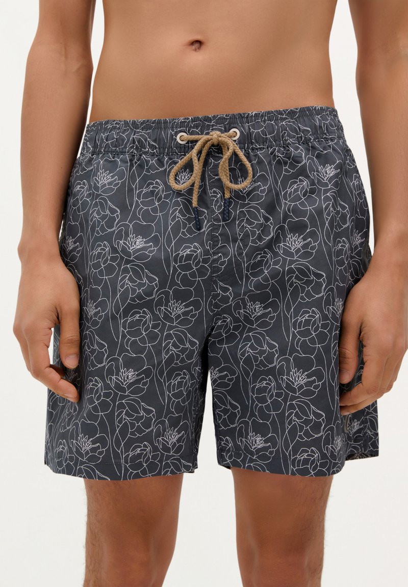 Shorts de baie navy cu un model floral alb, talie elastică cu un șnur bej și un material ușor, texturat.