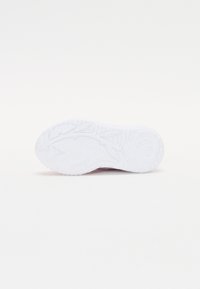 Semelle de sneaker blanche avec un motif de grip texturé, présentant des accents floraux et des éléments de design pincés. Matériau en caoutchouc lisse et durable.