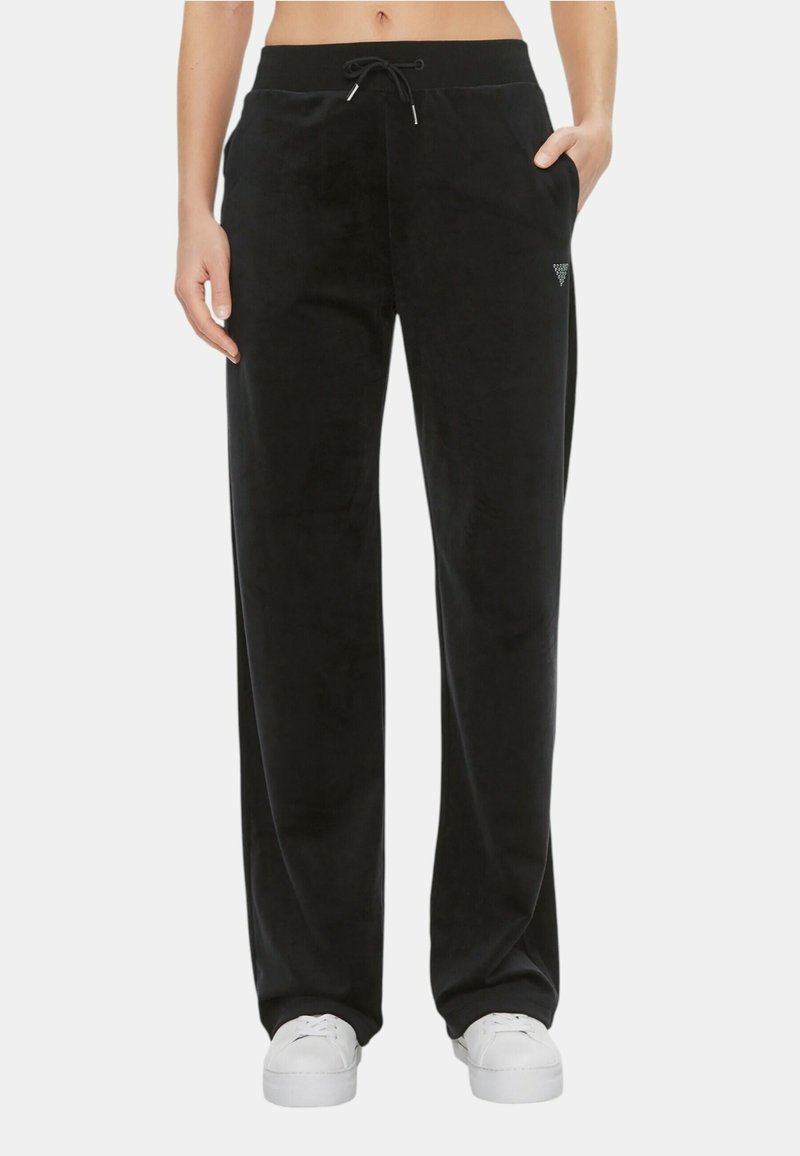 Pantaloni da tuta neri in velluto con vestibilità rilassata, cintura con coulisse, tasche laterali e un piccolo logo sul fianco sinistro.