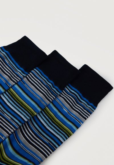 Trois chaussettes pliées avec des bords noirs et des rayures horizontales multicolores en bleu, vert, gris et noir sur un fond blanc.