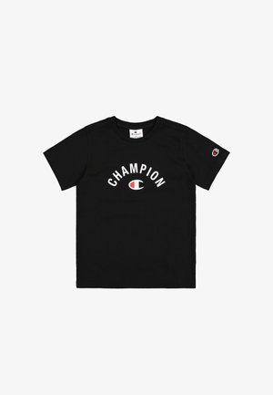 Camiseta de algodón negra con la inscripción "CHAMPION" en texto blanco en arco, con un logo rojo y blanco en la manga izquierda. Cuello redondo clásico.