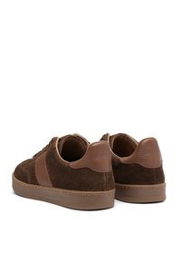 Pair of low-top brown suede sneakers with leather heel accents and rubber soles, viewed from the back on a white background.