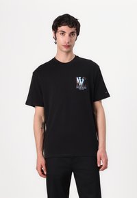 Zwarte katoenen t-shirt met een kleurrijke "NY" graphic op de borst, korte mouwen en een ronde halslijn. Eenvoudig en veelzijdig ontwerp.