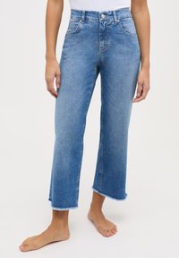 Lichtblauwe high-waisted jeans met een recht gesneden broekspijpen, afgewerkten zoom en subtiele vervaging. Voorzien van zakken en een metalen knoopsluiting.