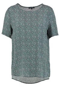 Kortærmet mørkegrøn bluse med lille hvid og teal blomsterdesign samt rund halsudskæring.