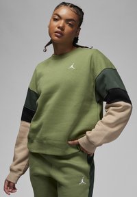Felpa verde con maniche di varia lunghezza in verde scuro, nero e beige. Presenta un logo Jordan bianco sul petto e polsini a coste.