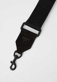 Czarny materiałowy pasek na ramię z zamszowymi akcentami, wyposażony w czarny metalowy haczyk oraz wytłoczone logo "Moschino" na skórzanej części.