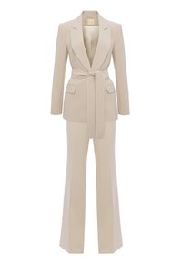 Beżowa marynarka dopasowana z paskiem w talii i dwoma przednimi kieszeniami, zestawiona z szerokimi spodniami w pasującym kolorze i tkaninie. Gładka tekstura.