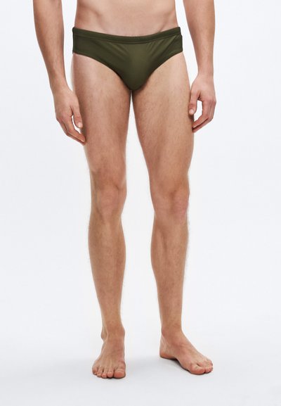 Maillot de bain slip vert à taille basse, confectionné dans un tissu lisse et léger. Dispose d'une taille élastique et d'une couvrance minimale.