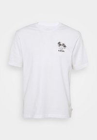 Valkoinen puuvillapaita, jossa on musta graafinen kuvio vasemmassa ylärintakohdassa, pyöreä pääntie ja lyhyet hihat.