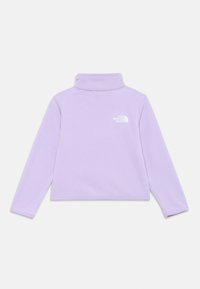 Lila flis pulover z dolgimi rokavi, visokim ovratnikom in belim logotipom "The North Face" na levem prsnem delu.