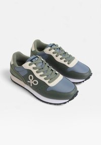 Zapatillas deportivas que presentan una combinación de materiales sintéticos en verde y azul, con acentos texturizados, cordones redondos y una suela de goma blanca.