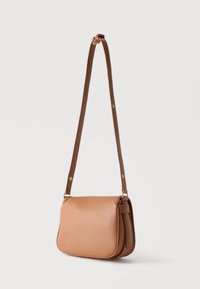 Τσαντάκι ώμου από δέρμα ταμπά με μακρύ ρυθμιζόμενο ιμάντα και κλείσιμο με πτερύγιο πάνω σε απλό λευκό φόντο.