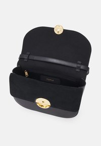 Borsa a mano in suede nero con un fondo in pelle nera lucida. Presenta una chiusura rotonda dorata e una semplice tasca interna con zip.