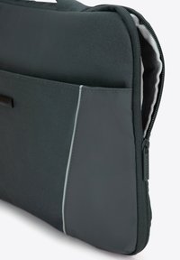 Bolsa de portátil de color gris oscuro con una tela texturizada, detalles en un gris más claro y un cierre con cremallera. Cuenta con un bolsillo frontal.