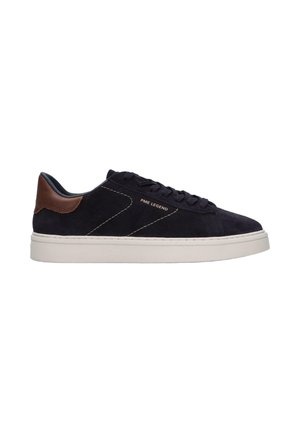 Baskets basses en daim noir avec patch en cuir marron au talon, semelle blanche, lacets noirs et logo PME Legend sur le côté.