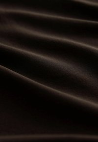 Dark brown fabric with a smooth texture, featuring gentle waves and subtle sheen, highlighting its soft, tactile qualities.