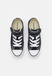 Fekete vászon sneakers fehér gumitalppal, fehér fűzővel és tépőzárral. Fehér varrásokkal és logóval az talpbetétjén.