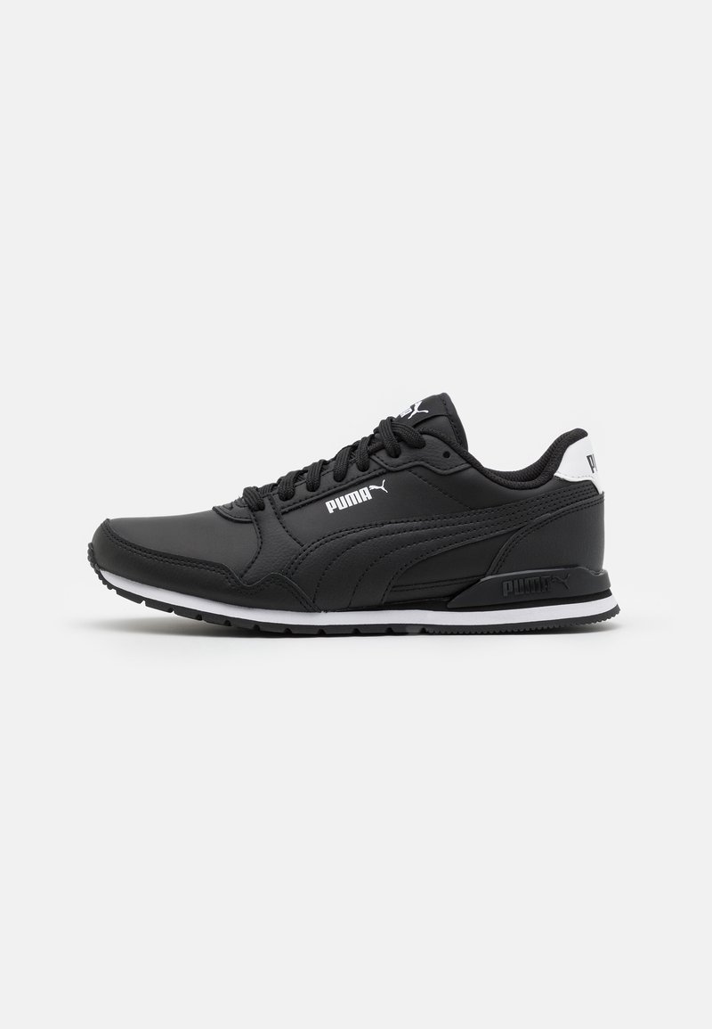 Baskets noires Puma avec semelle blanche et logo Puma, vue de côté sur un fond clair uni.