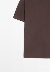 Brun kortærmet t-shirt lavet af blødt stof, med en lige pasform og enkelt design uden synlige mønstre eller logoer.