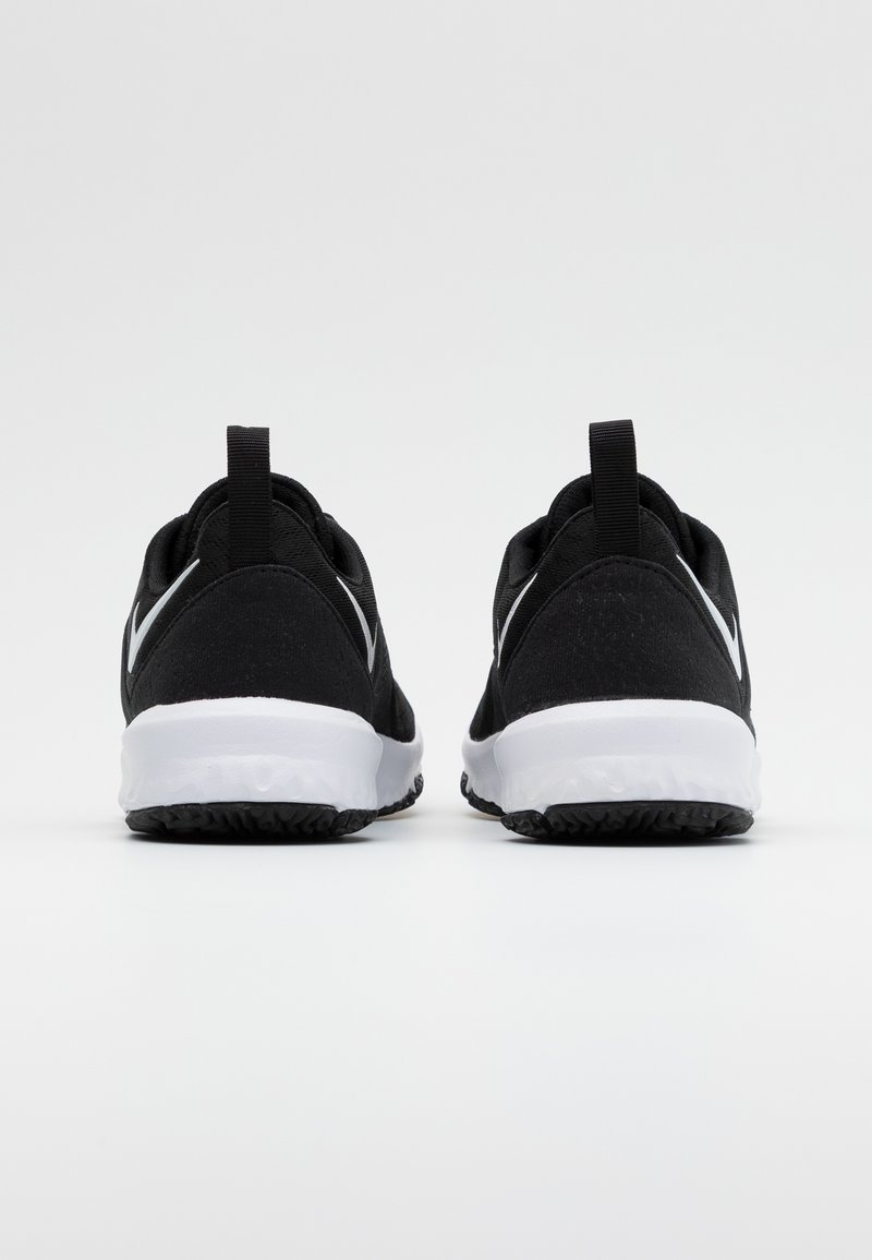 Zapatillas deportivas negras con suelas blancas, vistas desde la parte trasera mostrando las lengüetas de agarre y las suelas texturizadas sobre un fondo liso.