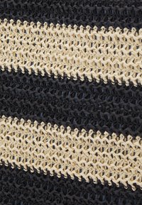 Gros plan sur un tissu étroitement tissé avec des rayures horizontales alternées beige et noir dans un motif en tricot texturé.