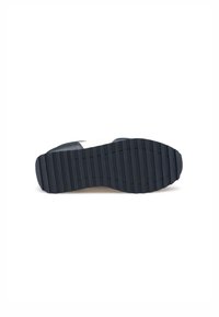 Suola di sneaker con fondo in gomma nera texturizzata e scanalature orizzontali per trazione, e una soletta centrale bianca solida.